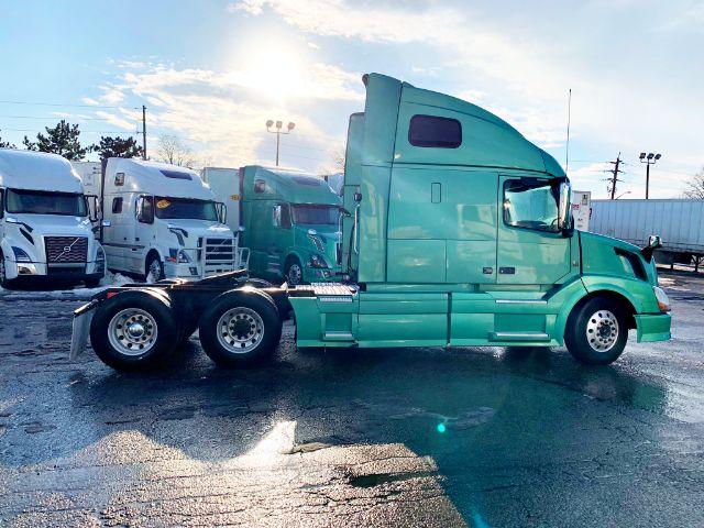 2015 Volvo VNL 670 conventional sleeper tractor in teal green, side view showing sleeper cabin, fuel tanks, dual rear axles, and front wheels.