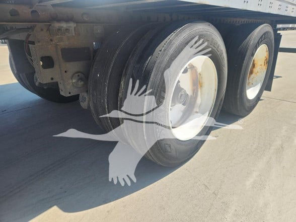 Trailer axles and wheels with dual tires, undercarriage and frame visible.