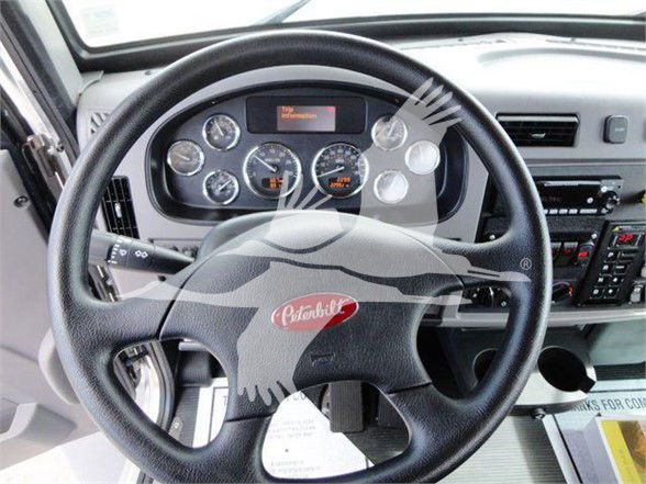 Peterbilt 337 interior showing steering wheel, gauge cluster, and dashboard controls.