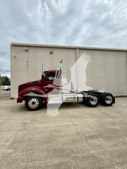 Kenworth T880 truck in side view showing long-bumper conventional cab with dual rear axles and red cab paint.
