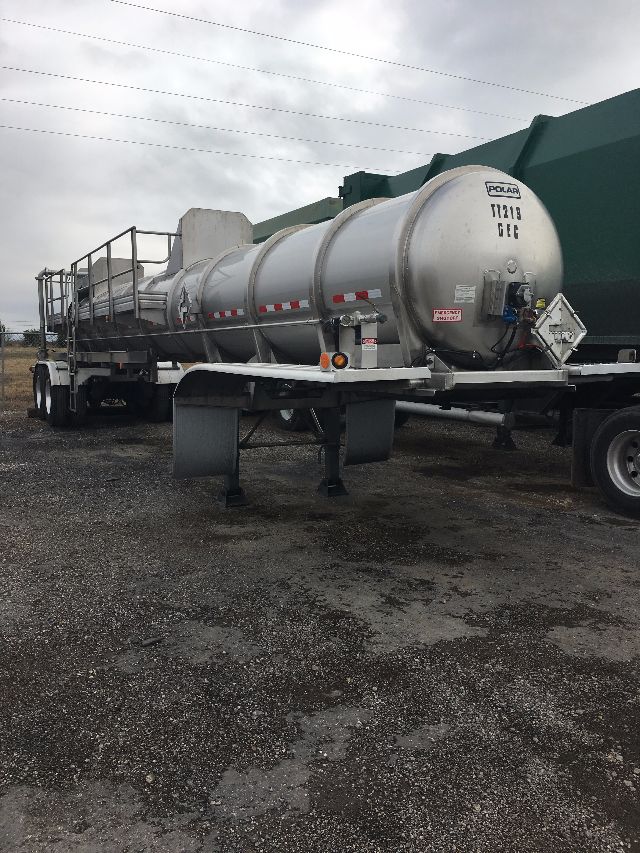 Tank trailer with cylindrical aluminum tank on dual-axle trailer, POLAR branding on rear, safety rails along top, reflective tape, mounting legs, and hoses at rear.