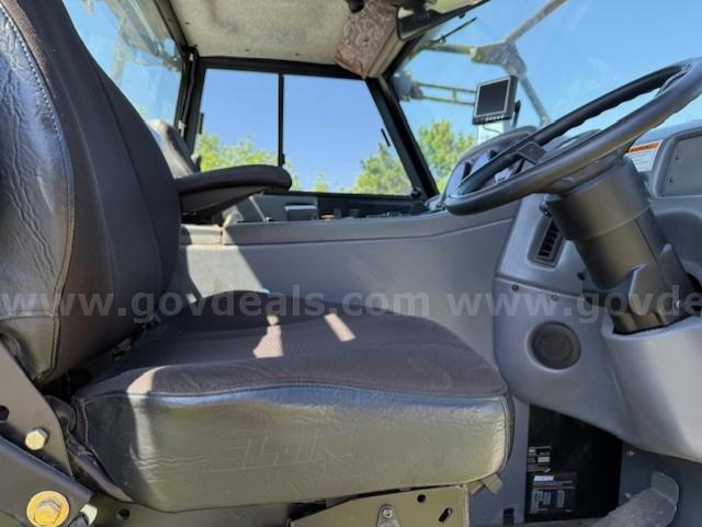 Cab interior of a 2010 Elgin Pelican NP sweeper truck showing driver's seat, steering wheel, and dashboard. No specific model text visible.