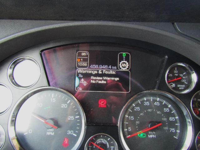 Dashboard of a 2020 Kenworth T680 showing gauge cluster, center display with warnings and miles, and various indicator lights.