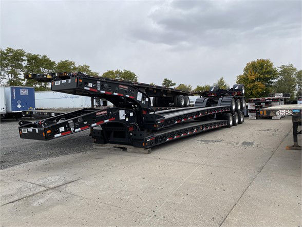 Trailer chassis with stacked lowboy sections, Fontaine Magnitude 55L Plus branding visible on frame rail and ramps.
