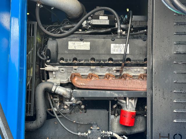 Engine bay of a Mack GU713 truck showing diesel engine with intake manifold and red oil filter; various hoses, wiring, and components in view.