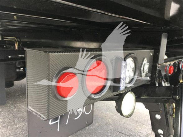 Peterbilt 337 tow truck rear with toolbox and lights. Visible text: 9/50 written in white on the black mudflap. Compact rectangular toolbox with red circular reflectors and multiple round lights.