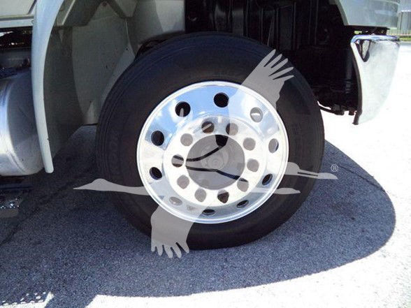 Truck front wheel with polished steel rim and black tire; partial cab and fender visible.