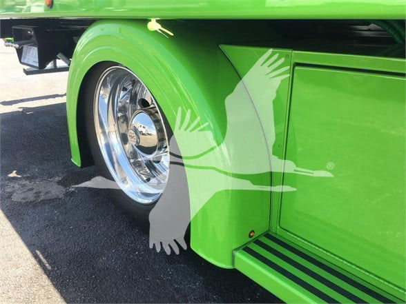 Green Peterbilt truck with chrome wheel, fender, and side storage compartment. No visible text/labels readable.