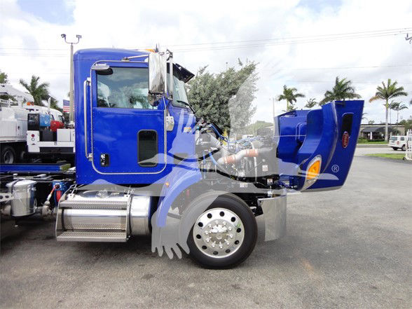 Peterbilt 337 truck with blue cab, air filter housing, and hood open showing engine bay and chrome fuel tanks.