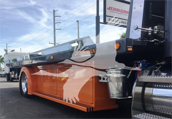 Peterbilt 337 truck in a tow configuration with orange lower body panels and chrome fuel tanks visible