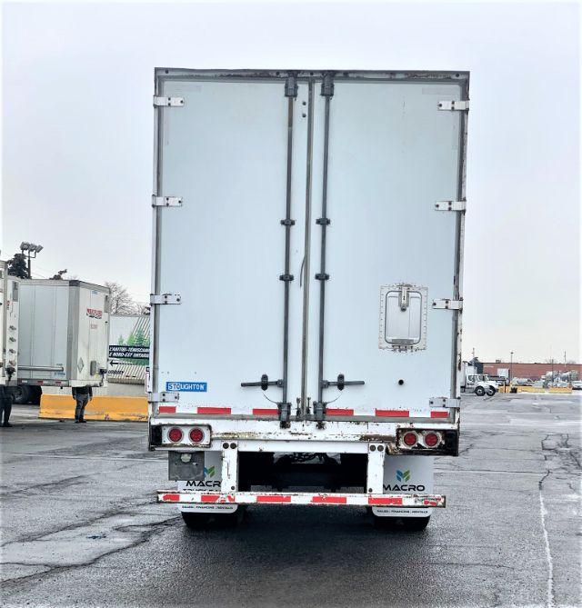Rear view of a 2013 Stoughton dry van trailer with double rear doors, light bar, and bumper stickers.