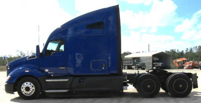 Blue 2020 Kenworth T680 cab and chassis tractor side view with sleeper cab, showing wheel hubs and fuel tanks.