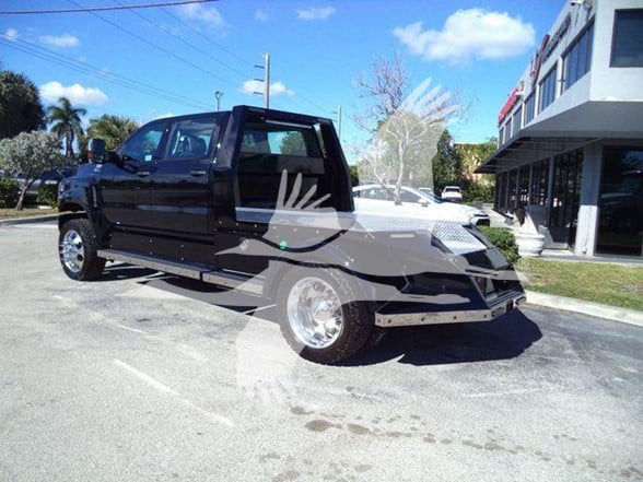 2023 International CV heavy haul truck in a parking lot showing black cab and flatbed with chrome wheels.