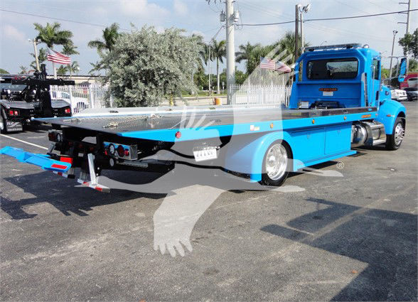 Peterbilt 337 tow truck in blue with flatbed, rear view showing hydraulic equipment and dual rear wheels.