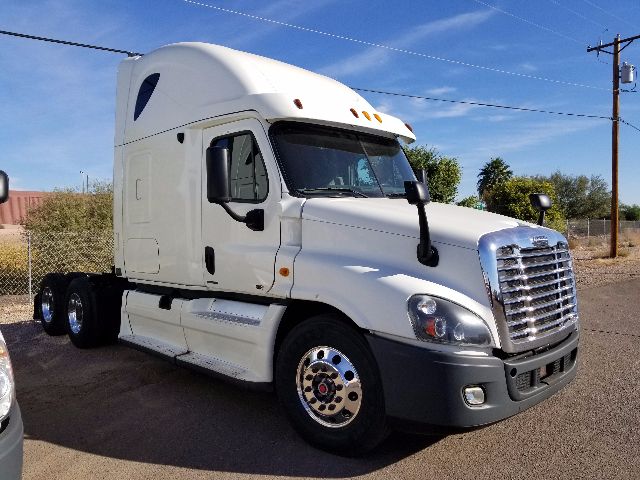 Freightliner Cascadia semi-truck tractor in white, front grille visible, sleeper cab with aerodynamic top, dual rear axles, chrome wheels.