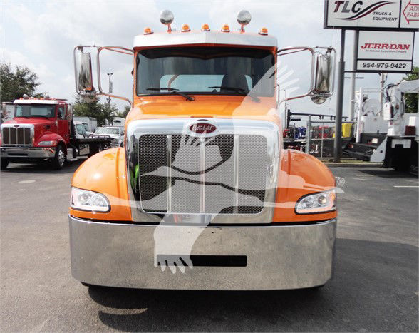 Peterbilt 337 front view showing orange cab and chrome grille with large bumper.