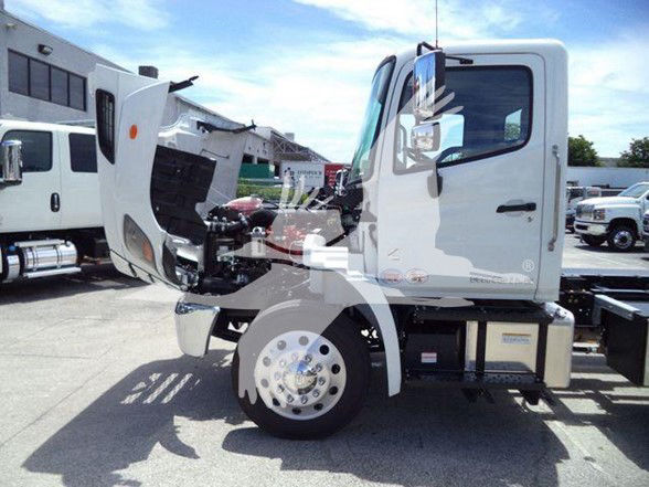 Truck cab of a 2025 Hino L6 in-service with open hood showing engine bay and front wheel.