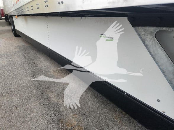 Side view of a new 2026 Wabash trailer showing logo graphics of birds on the lower panel.