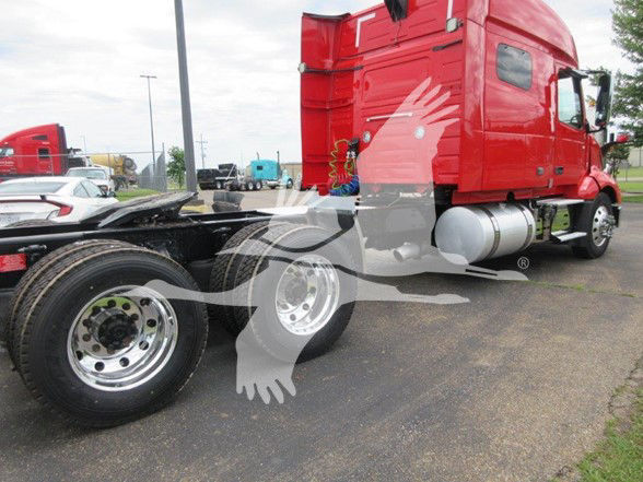 Volvo VNL64T740 truck tractor side view showing red sleeper cab and rear dual axles with chrome wheels.