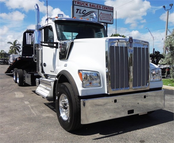Kenworth W900 truck in white with chrome grille and bumper, side exhaust stack, front view.