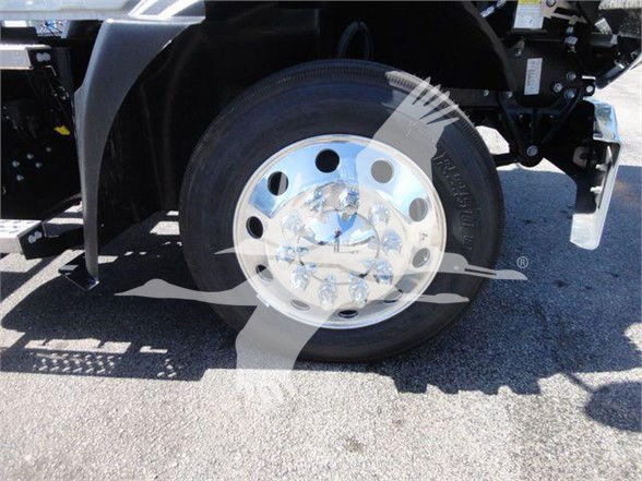 Mack MD6 truck front wheel showing aluminum hubcap and tire with wheel well.