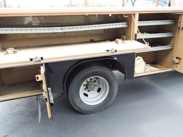 2016 Ford F350 Crew Cab Utility truck side showing open service compartments and wheel.