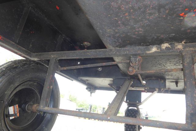 Underbody view of Agri-Metal CA8064 trailer showing suspension arms, wheel, and frame components.