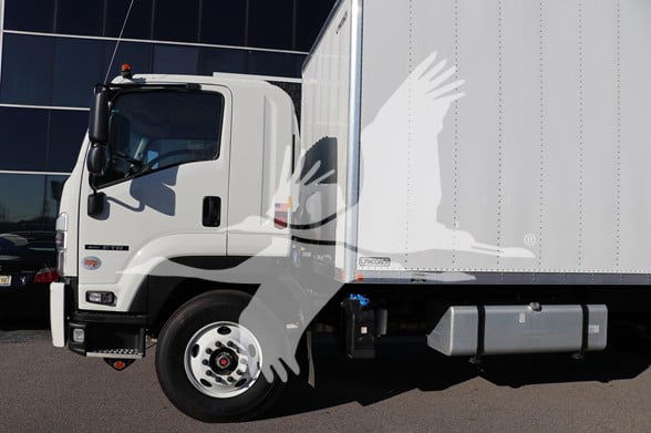 Isuzu FTR box truck side profile showing cab and cargo area with wheel and front bumper.