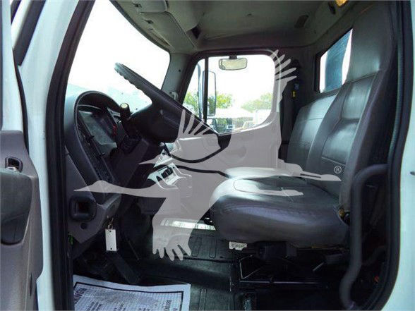Freightliner cab interior view showing driver seat and steering wheel with dashboard details visible.