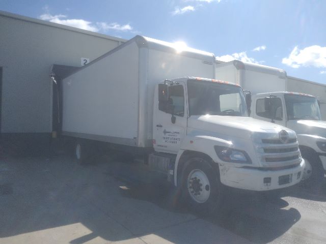 Box truck with white cab and box, 2017 Hino 268A, side view in a lot.