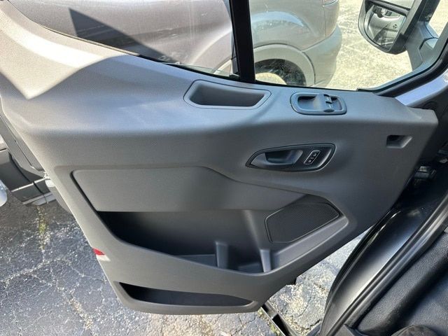 Vehicle interior door panel showing window/lock controls and storage pocket.