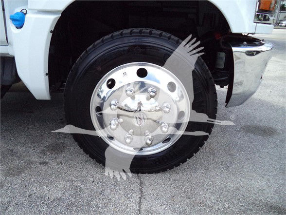 Front wheel of a white Chevrolet Silverado 6500HD with chrome hubcap, tire details visible.