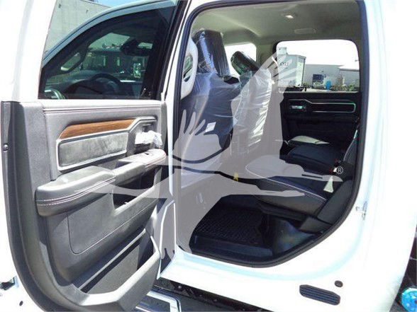 Truck interior showing open rear passenger door with black and tan interior, plastic seat covers on front seats. Faint watermark over image.