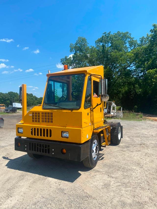 Yellow Ottawa yard spotter 4x2 truck front-left view with cabin, grille, and dual rear wheels.