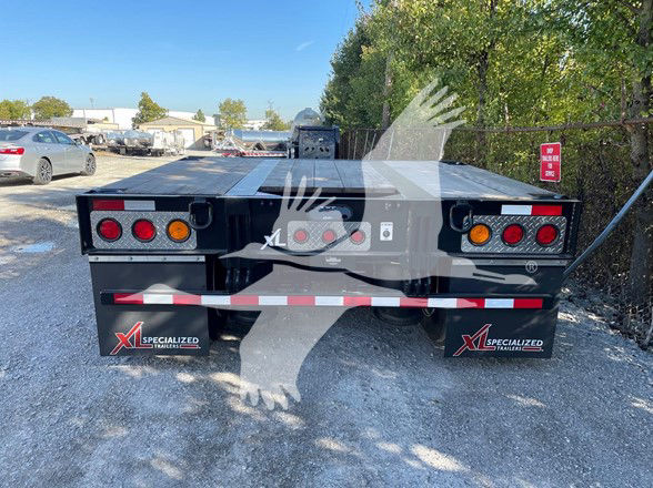 XL Specialized trailer deck showing rear view with dual round taillights and mud flaps, flatbed with expandable double drop design, branding decals visible.