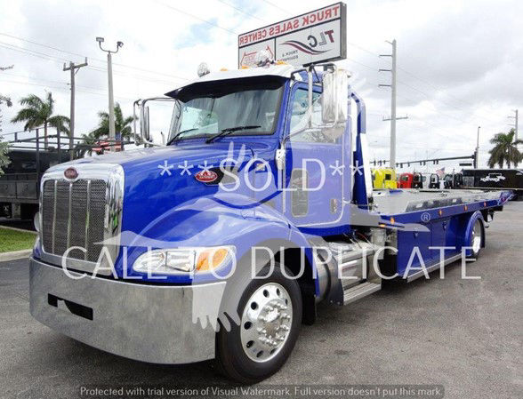 Blue 2022 Peterbilt 337 tow truck showing front grille and flatbed, SOLD watermark across image.