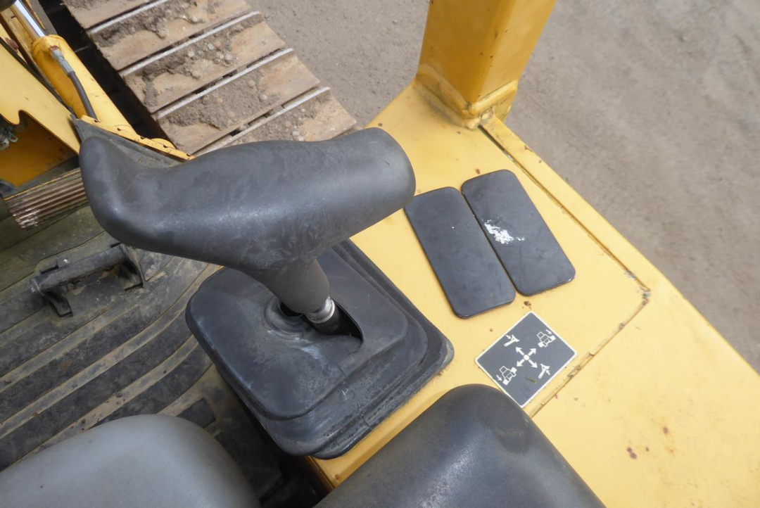 John Deere 650HLT cab interior showing operator seat and gear lever with joystick-style controls and pedal area.