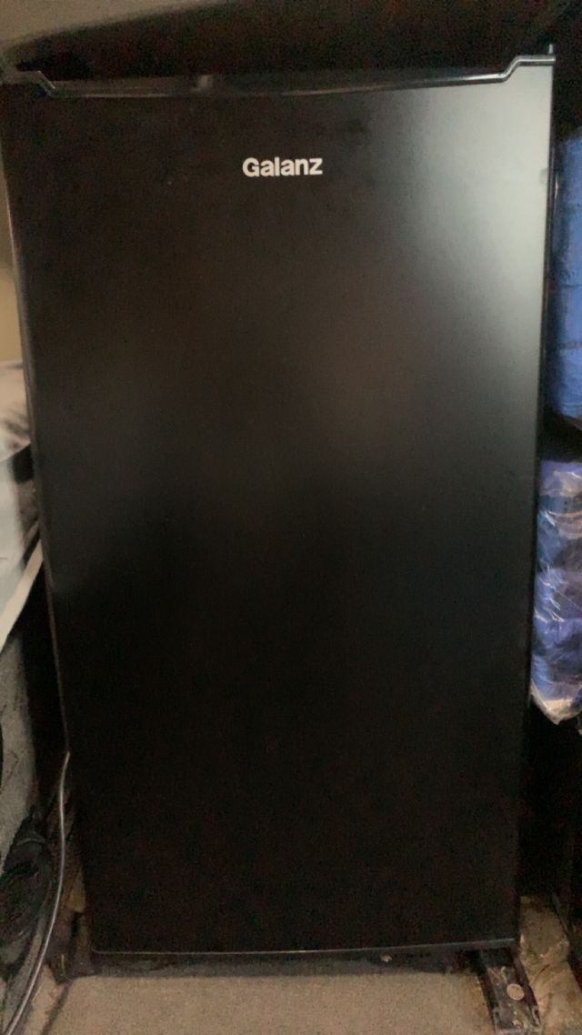 Galanz black mini fridge/freezer standing upright.