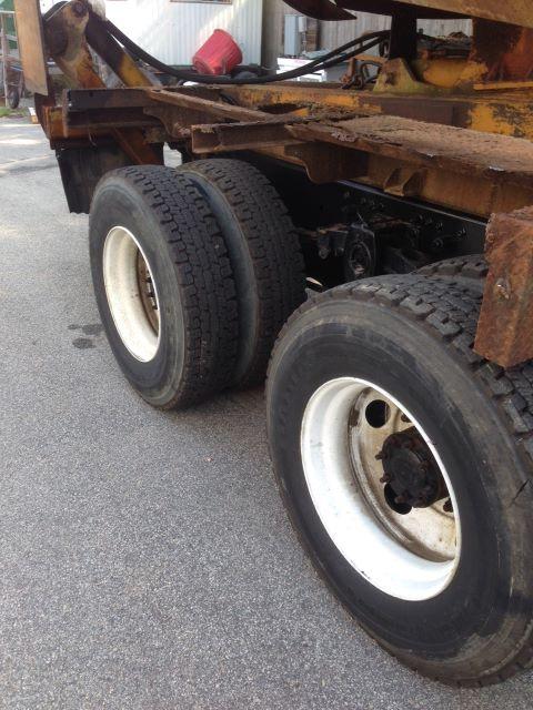 Cab and Chassis truck wheels and suspension components visible, with stacked tires and rusty metal frame.