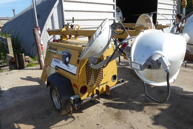 Allmand Night Lite Pro portable light tower on trailer with mounted flood lights and generator, yellow equipment, side view.