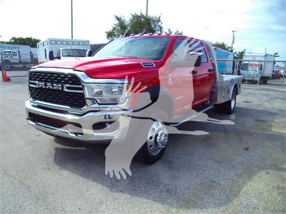 Ram 5500 SLT flatbed truck front left angle with red cab and chrome grille. Visible text includes RAM on grille and DODGE RAM badge. No other legible labels or numbers clearly readable.