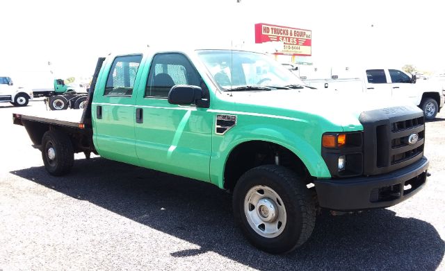 Ford F-250 4x4 crew cab flatbed truck in green with black grille and flatbed rear