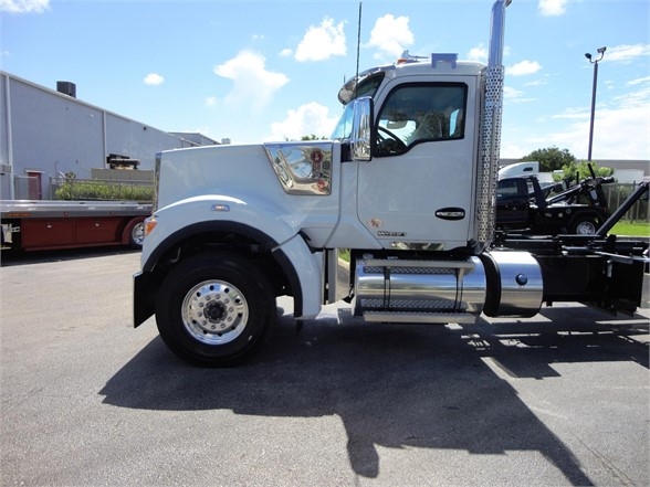 Kenworth W900 truck side view showing chrome fuel tank and cab with steps.