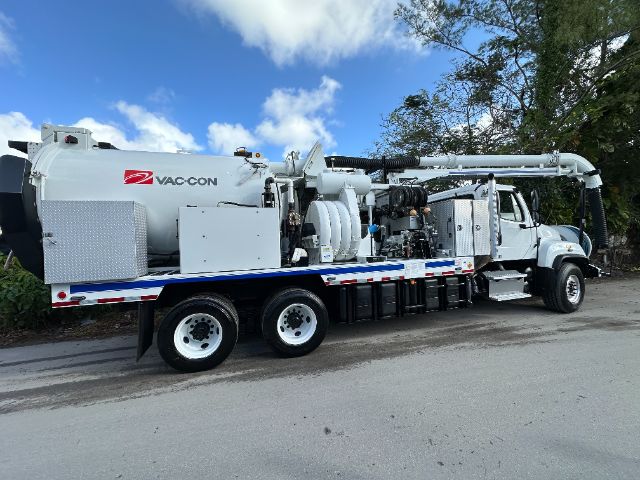 Vac-Con branded vacuum truck on a flatbed with long hose reel and equipment, 2014 Freightliner 114SD, side view showing tanks and machinery