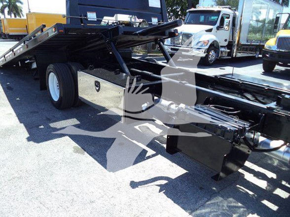 Ford F650 chassis and flatbed tones with wheel and hitch components visible in an outdoor lot.