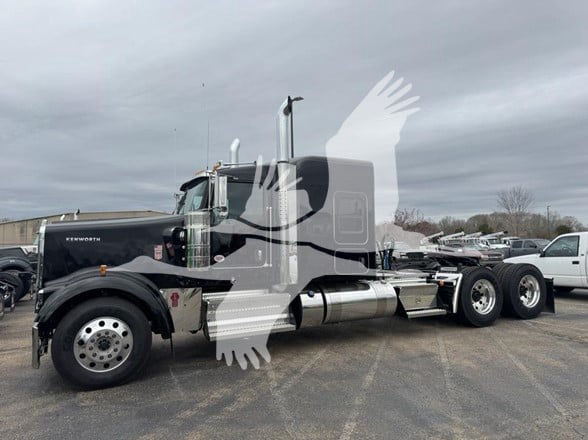 Kenworth W900L conventional sleeper truck in black with chrome exhaust, showing front left side and long wheelbase.