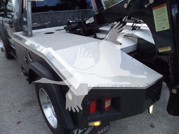 Tow truck bed area of a 2017 Ford F450 with aluminum diamond plate surface and rear lights visible.