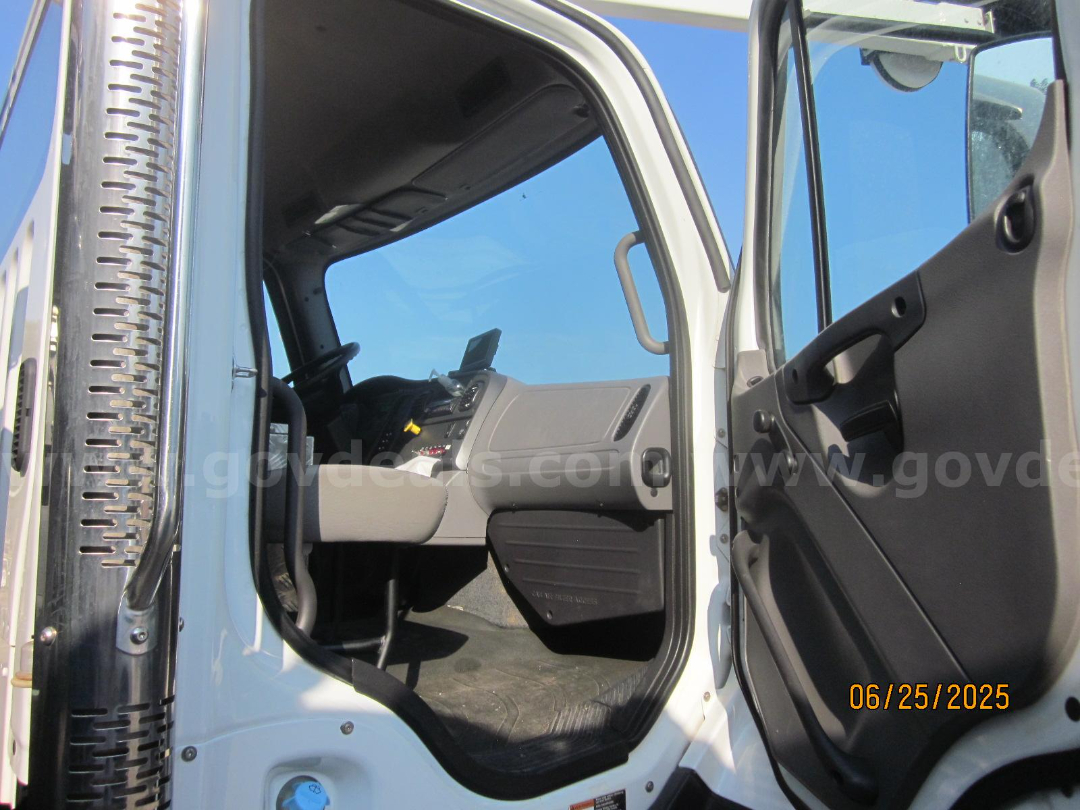 Truck cab interior of a Freightliner Vactor truck shown with open door and dashboard visible