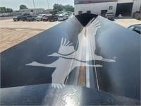 New dump trailer showing logo of a bird with wings on the black metal surface.
