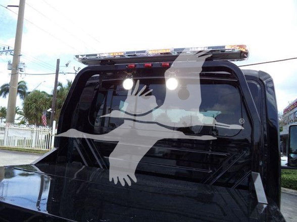 Truck rear window with large white decal of a person reaching forward. Limited visible text: none.